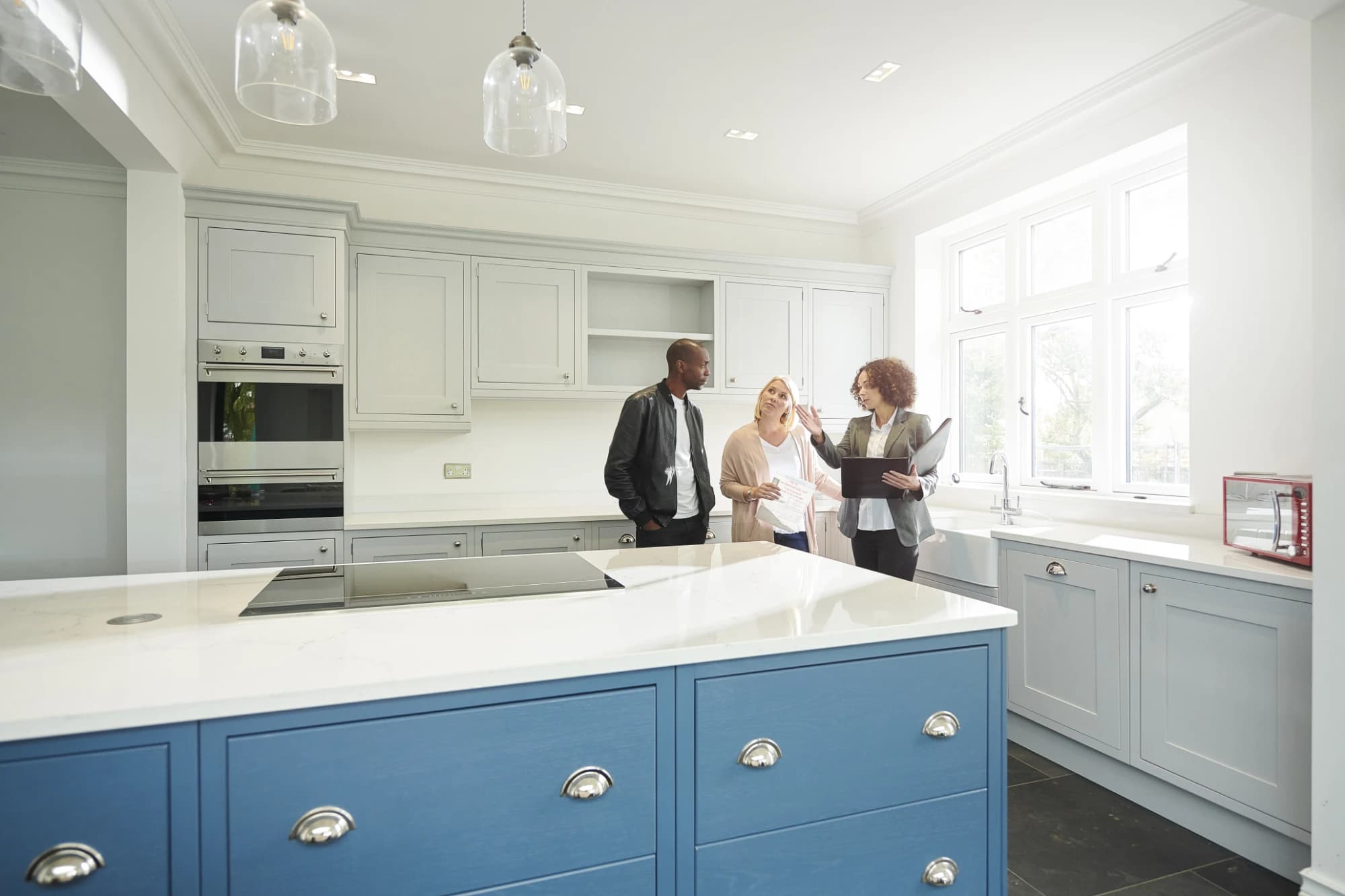 Realtor handing keys over to new buyers in a kitchen